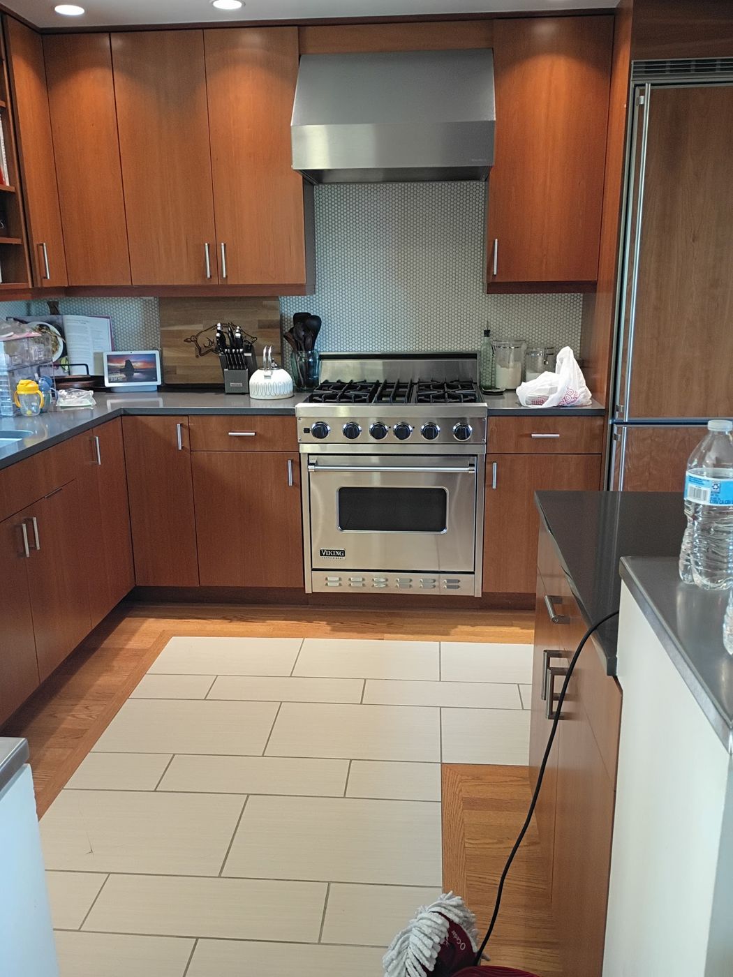 Clean kitchen with wood cabinets, range and hood